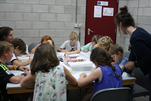 Knutselende kinderen aan één grote tafel